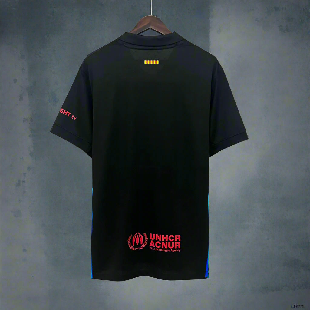 Black Barcelona jersey with red text and logos on a hanger against a geometric background