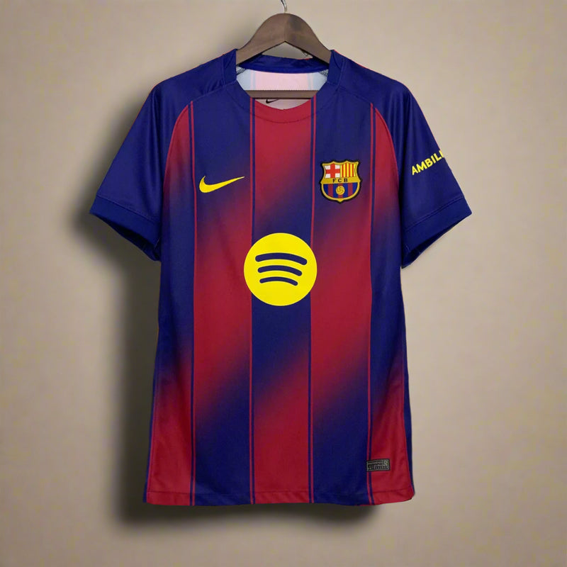 Blue and red sports jersey with a yellow logo on a hanger against a geometric patterned wall.