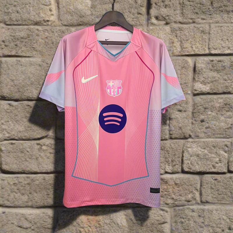 Pink sports jersey with brand logos on a hanger against a geometric patterned background