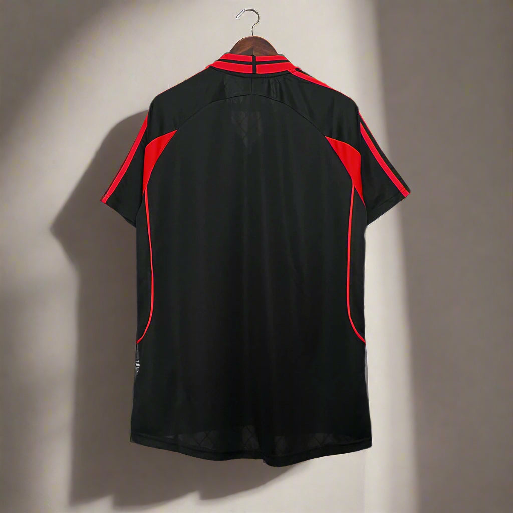 Black shirt with red accents on a metal stand against a grid background